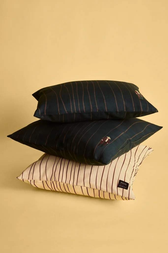Tres cojines de algodón de la colección Kave x Justine Franco, con rayas y pequeños motivos bordados.